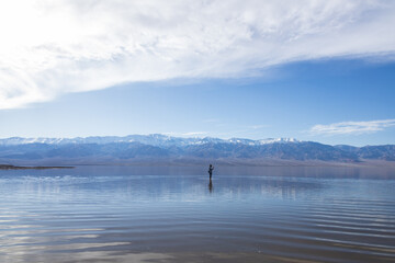 Fototapeta premium Man standing in Lake Manly at Badwater Basin in Death Valley National Park, California