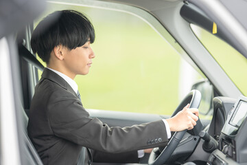 車とスーツの男性