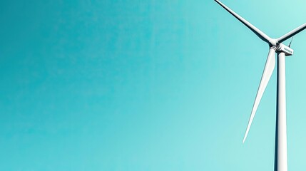 Wind turbine against a clear blue sky, symbol of renewable energy and sustainability.