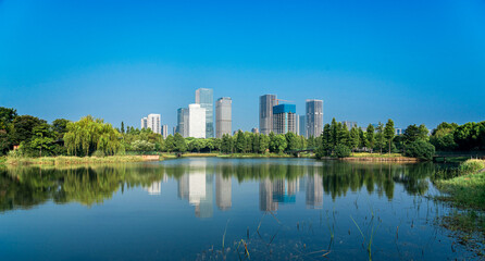Serene Urban Landscape with Reflections of Skyscrapers and Lush Greenery