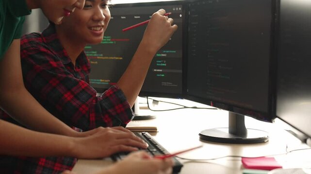 Slow motion back end software developer engineer for computer programming working together on debugging writing computing code, solving complex algorithms display on monitor in office. Burgeoning