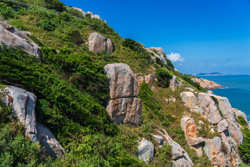 Serene Coastal Landscape with Rocky Cliffs and Lush Greenery