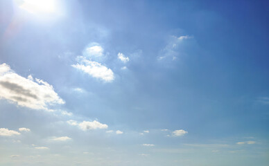 Fototapeta premium Serene Blue Sky with Fluffy Clouds and Bright Sunlight