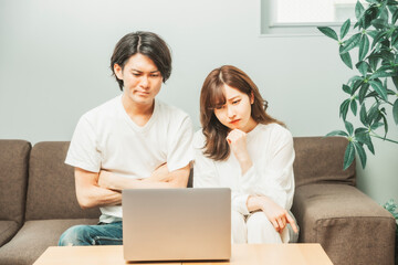 部屋にいる男女（ノートパソコン・困る）
