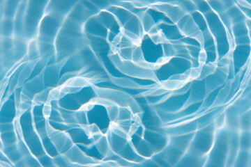 Blue water with ripples on the surface. Defocus blurred transparent blue colored clear calm water surface texture with splashes and bubbles. Water waves with shining pattern texture background.