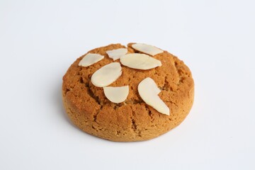 One tasty cookie with almond flakes on white background