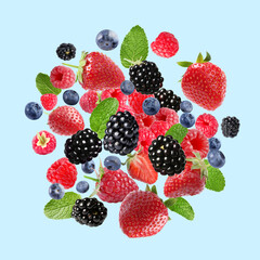 Mix of fresh berries in air on light blue background