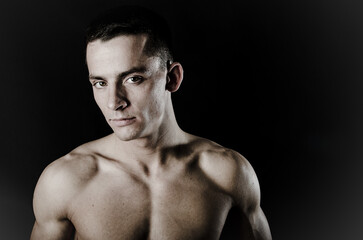 Young attractive man with athletic body posing in studio.