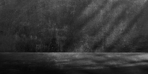 Light dark gray background with cement wall texture. Minimalist abstract blank background for product presentation with light shadow from window.