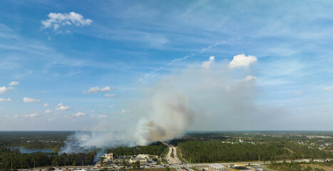 Aerial view of strong wildfire burning severely in North Port city, Florida. Natural disaster during dry season in jungle woods
