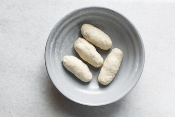 Overhead view of noodles dough  in a grey bowl, top view of homemade biang biang noodles, process of making hand pulled noodles
