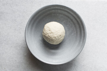 Fototapeta premium Overhead view of noodles dough in a grey bowl, top view of homemade biang biang noodles, process of making hand pulled noodles