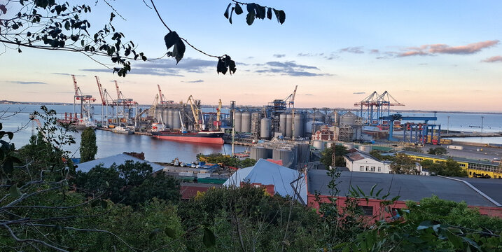 View of the Odessa port terminal.
Port harbour infrastructure, many cranes, grain elevator and a berth for ships in Odessa.