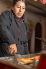 Latin american street food vendor preparing chicken broaster at food stall