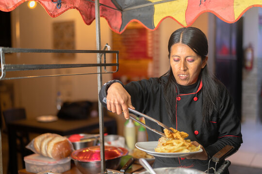 Latin american street food vendor preparing chicken broaster and fries
