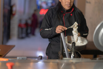 Cook preparing chicken broaster at street food stand
