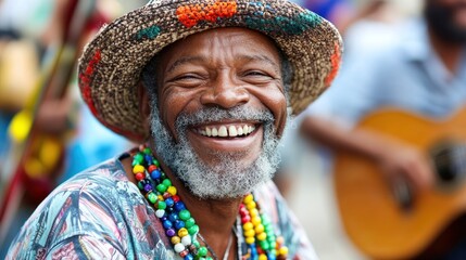 A close-up portrait of a joyful, elderly man with a warm smile wearing a colorful shirt, hat, and beaded necklace, with a blurred background of musical instruments and people.