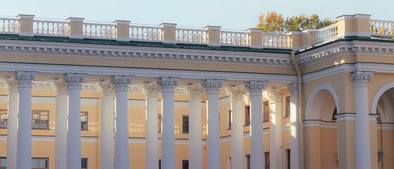 Fototapeta premium Classical building with white columns and decorative balustrade in bright daylight. Architectural detail of historic structure. Classical architecture and cultural heritage concept.