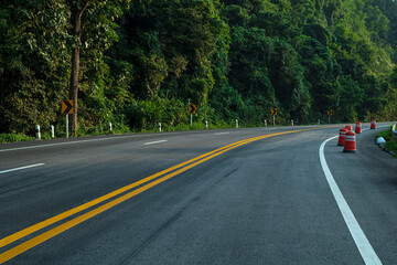 Long curvy forest asphalt road over the hills. Beautiful curved road in the forest. Side view of...