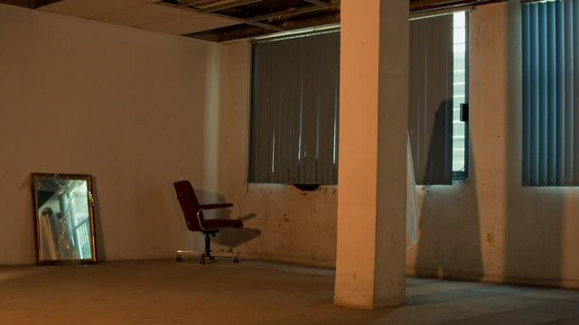 Ghost posing in a mirror, saying hello, or saying goodbye, dancing. Abandoned office. Person in ghost costume for halloween. Get scared. Wearing sunglasses. Fire effect ambience.