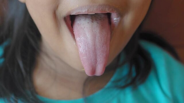 A child playfully sticking out their tongue, expressing a joyful and carefree attitude