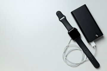 A power bank with a smart watch on a light background