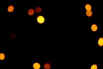 Many soft orange, yellow and red blurry bokeh light on dark background in Christmas and New Year...