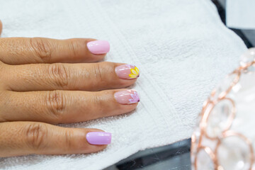 Beautiful latina woman's hands with a nice decoration on her nails. Beauty and fashion. Femininity, nail spa. Copy space.
