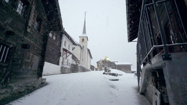An old village in the Swiss mountains, Blatten near Naters in winter with heavy snowfall and snowstorms - static shot