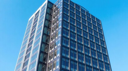Obraz premium Modern office building standing tall with a clear blue sky in the background, headquarters, professional