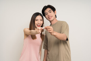 Happy family asian couple attractive in various action gesture holding house key on isolated white background. Cheerful Smiling young man and woman buy new home showing key of the house