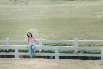 A serene walk in nature embracing the tranquility of a sunny day with a fashionable umbrella and vibrant greenery