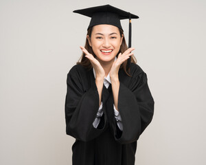 Happy asian woman in graduation costume with cap on isolated background. College degree successful education graduation in university