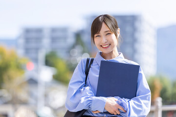ファイルを抱えた笑顔の女性　Business