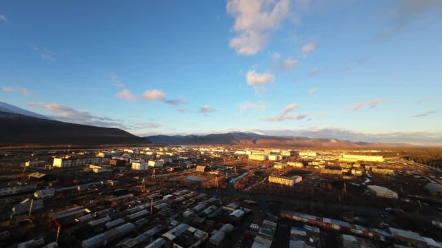 Witness the breathtaking transformation of Tsetserleg as the sun rises, casting golden rays over the winter cityscape, illuminating the chilly morning sky and highlighting the mountainous backdrop.