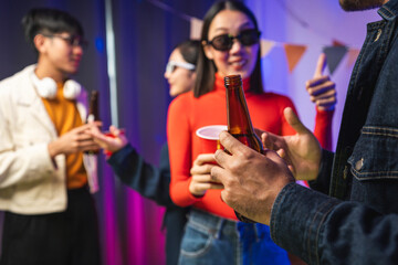 New Year's Party. Group of asian friend party in the house with disco light having fun and dancing together. Enjoy Singing karaoke listening music drinking beer celebration in new year happy hour.