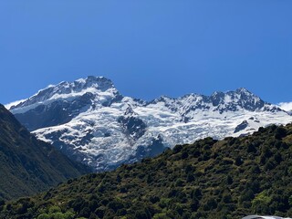 Snow capped peaks of Mount Cook and blue sky with clouds , Mount Cook National Park, New Zealand 