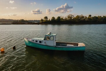 Naklejka premium Fishing boat moored in the harbour at sunset. Orr's Island, Harpswell, Maine, United States.
