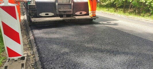 Układanie nowej nawierzchni asfaltowej na drodze. © WalDec
