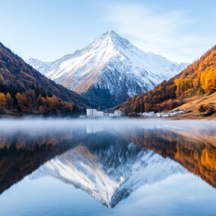 Obraz premium A mountain with snow-capped peak reflected in a still lake with autumn trees on the slopes.