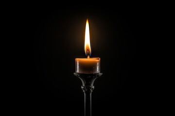 Fototapeta premium A single candle flame illuminating darkness in a serene and peaceful setting at night