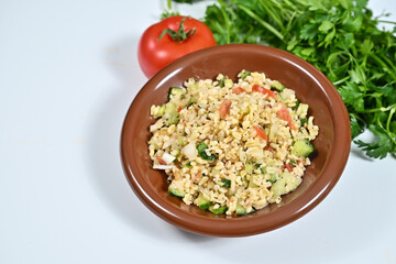 a small brown bowl filled with rice next to some veggies