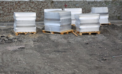 The paving slabs packed in polyethylene are prepared for laying instead of the removed asphalt