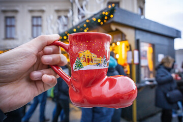 hands holding red and white shoe cup