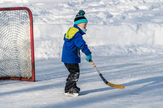 Happy child playing hockey in winter