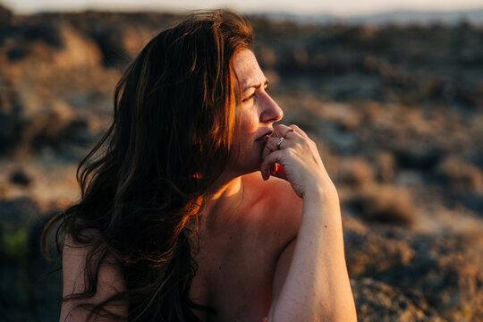Thoughtful woman gazing into the distance in warm evening light
