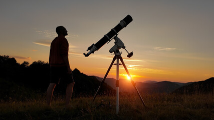 Amateur astronomer looking at the evening skies, observing plane