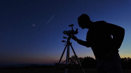 Amateur astronomer looking at the evening skies, observing planets, stars, Moon and other celestial...