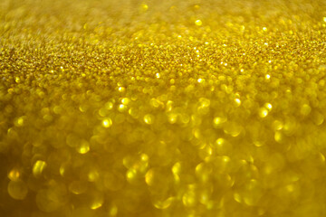 Golden beautiful blurred bokeh background. Holiday texture. Wallpaper. Glitter light spots on golden background, defocused. Copy space.