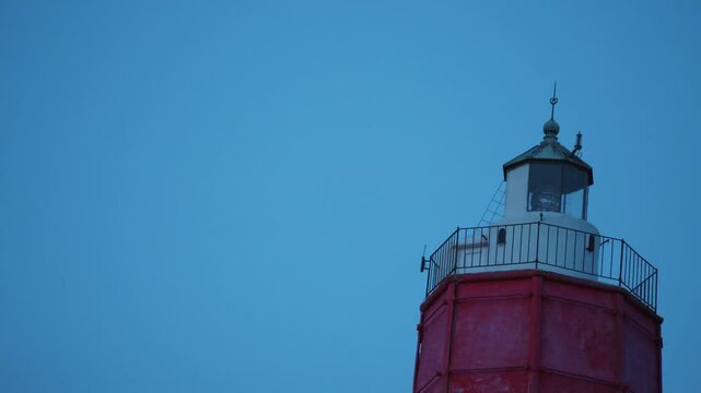 Close up of old lighthouse blinking in the dusk